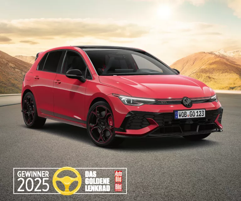 Roter VW Golf GTI auf einer leeren Bergstraße mit sanften Hügeln und Bergen im warmen Abendlicht, ausgezeichnet als „Gewinner 2025 – Das Goldene Lenkrad“.