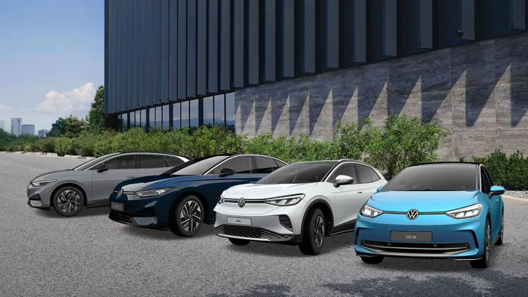 Drei VW Modelle stehen in der Mitte eines vollbesetzten Fußballstadions.