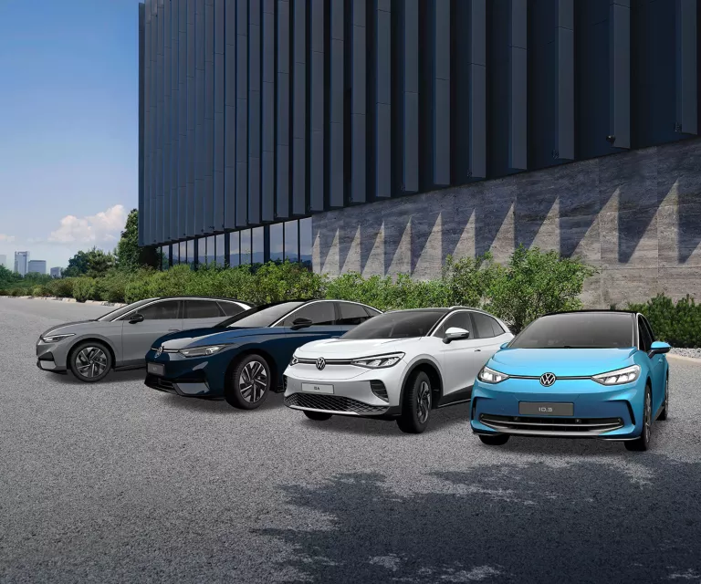 Drei VW Modelle stehen in der Mitte eines vollbesetzten Fußballstadions.