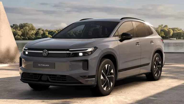 Ein grauen VW ID. Tiguan, der vor einem modernen Gebäude parkt.