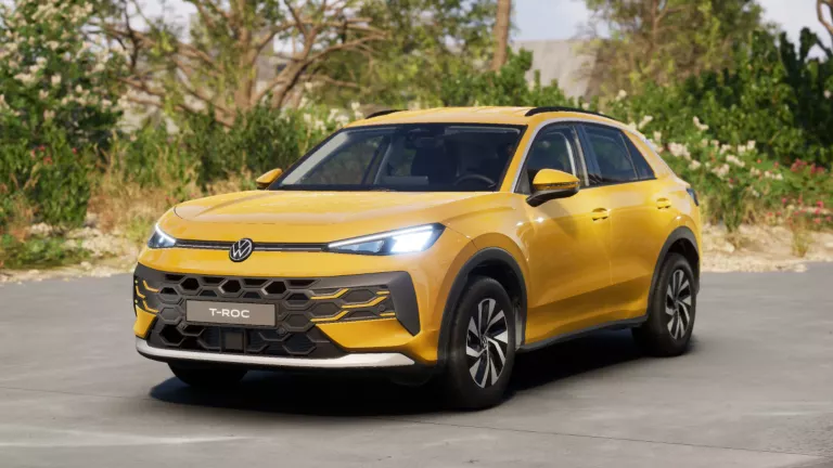 Gelber VW T-Roc SUV, Frontansicht, geparkt auf Asphalt, umgeben von Bäumen und Sträuchern.