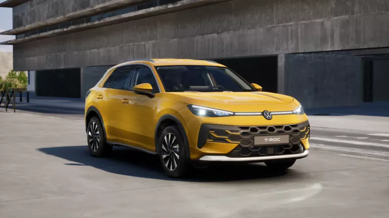 Seitliche Ansicht eines gelben VW T Roc Style auf der Straße vor einem Gebäude