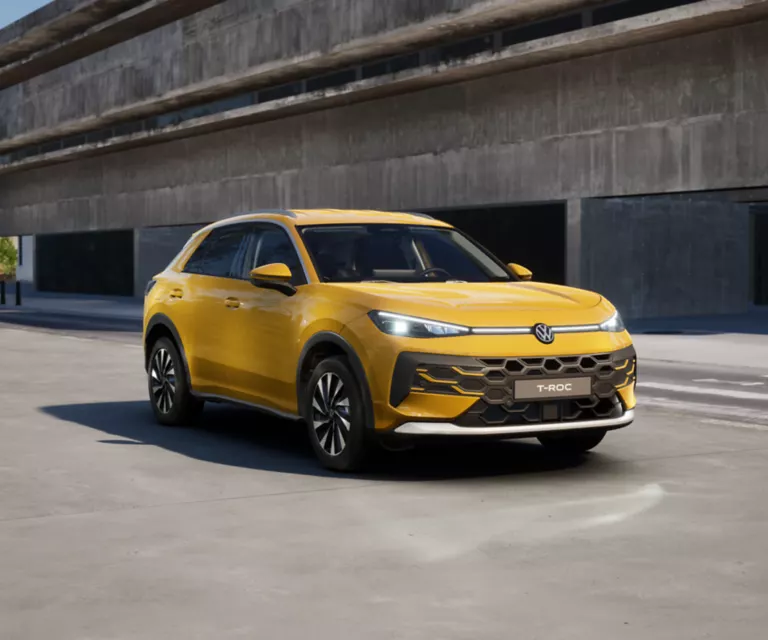 Seitliche Ansicht eines gelben VW T Roc Style auf der Straße vor einem Gebäude