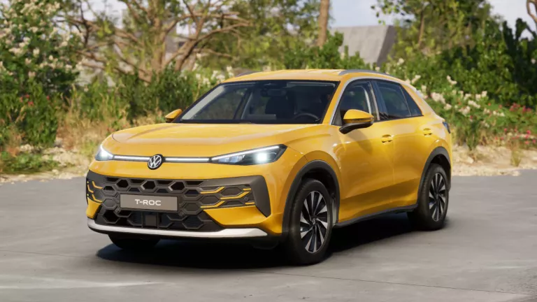 Gelber VW T-Roc SUV, Frontansicht, geparkt auf Asphalt, umgeben von Bäumen und Sträuchern.