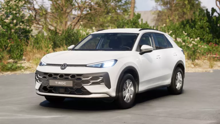 Weißer VW T-Roc SUV, Frontansicht, geparkt auf Asphalt, umgeben von Bäumen und Sträuchern.