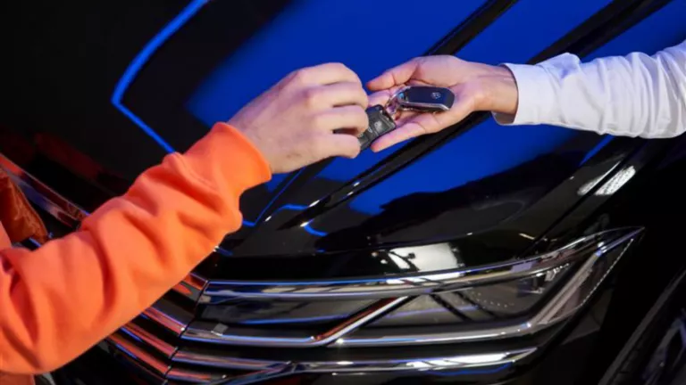 Unas manos haciendo una entrega de llaves sobre un VW