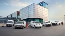 Pylon mit Volkswagen-Logo und Schriftzug 'Nutzfahrzeuge' vor Glasfassade eines Gebäudes