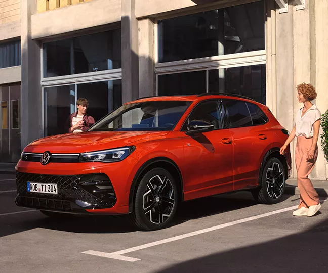 Dunkelgrauer VW Tiguan mit fünf Türen, LED-Scheinwerfern und Radkappen, Frontansicht leicht von rechts