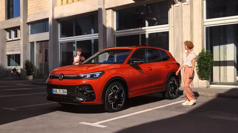 Dunkelgrauer VW Tiguan mit fünf Türen, LED-Scheinwerfern und Radkappen, Frontansicht leicht von rechts