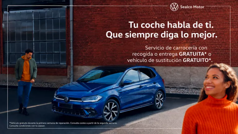 Un hombre y una mujer junto un Volkswagen azul