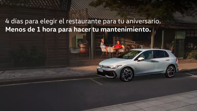 Volkswagen blanco aparcado delante de una cafetería