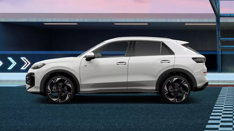 Seitenansicht eines weißen T-Roc Sportwagens mit fünf Türen und sportlichen Felgen, auf einer Rennstrecke mit blauen und grauen Markierungen.