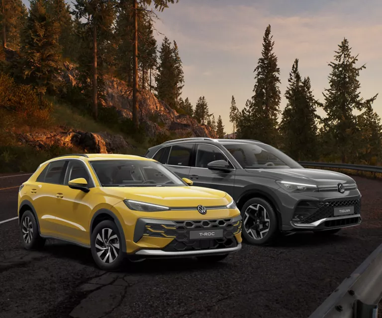 T-Roc und Tiguan im Wald mit herbstlichen Bäumen