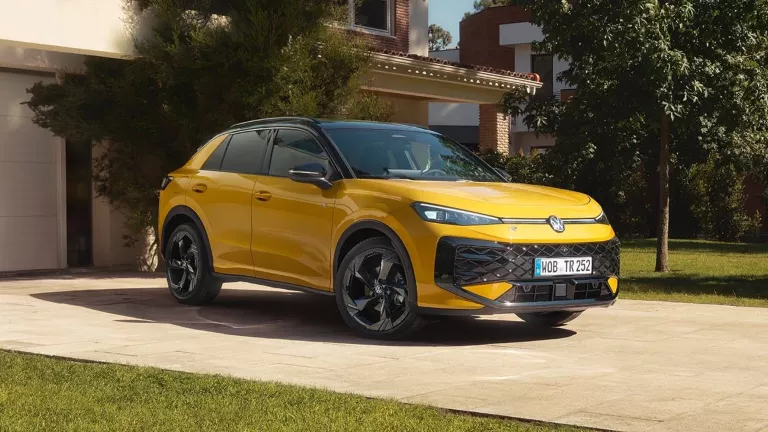 Ein gelber VW T-Roc R-Line steht vor einem modernen Gebäude.