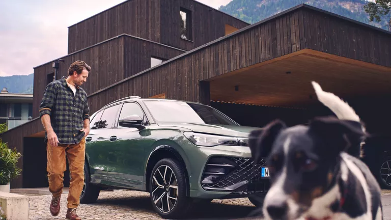 Dunkelgrauer VW Tiguan mit fünf Türen, LED-Scheinwerfern und Radkappen, Frontansicht leicht von rechts