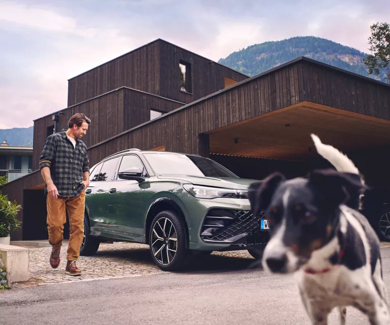 Dunkelgrauer VW Tiguan mit fünf Türen, LED-Scheinwerfern und Radkappen, Frontansicht leicht von rechts