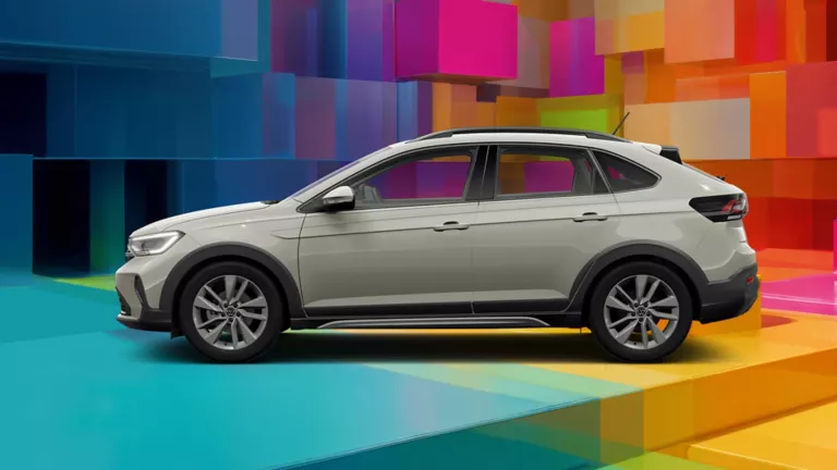 Seitenansicht eines hellgrauen VW Taigo vor einem bunten, geometrischen Hintergrund aus leuchtenden 3D-Blöcken.