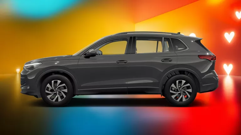 Seitliche Ansicht eines grauen VW Tiguan vor einem farbigen Hintergrund mit Herzsymbolen