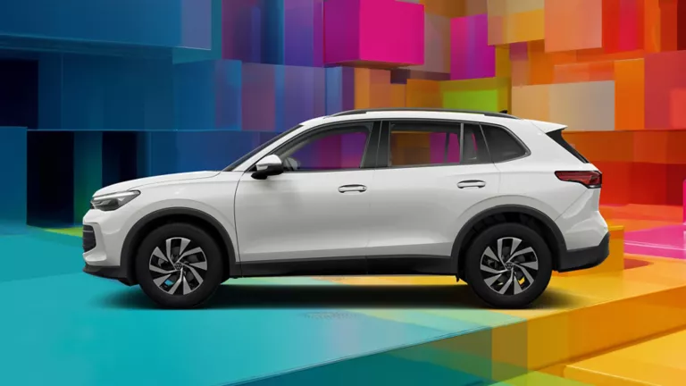 Seitenansicht eines weißen VW Tiguan vor einem bunten, geometrischen Hintergrund aus leuchtenden 3D-Blöcken.
