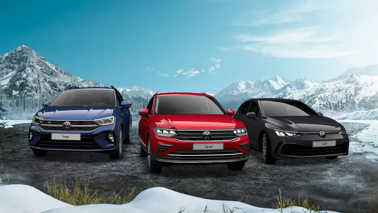 VW-Modelle Tiguan, Taigo und Golf parkend, im Hintergrund blauer Himmel und Berggipfel