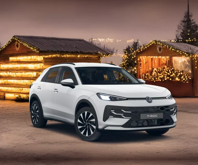 Zwei VWT-Roc, ein gelber von vorne links und ein roter von hinten rechts, vor einer Wand mit dem Schriftzug "DRIVING HOME DAYS".