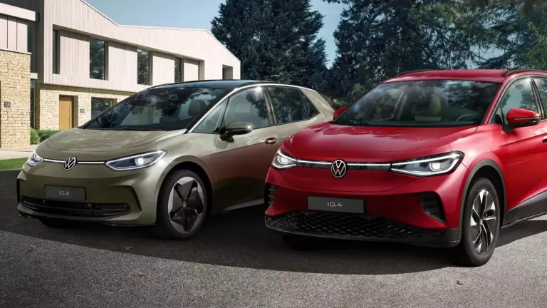 VW ID.3 und VW ID.4 stehen auf Parkplatz, im Hintergrund Wohngebiet