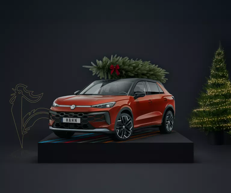 Weihnachtsbaum auf dem Dach eines roten VW T-Roc