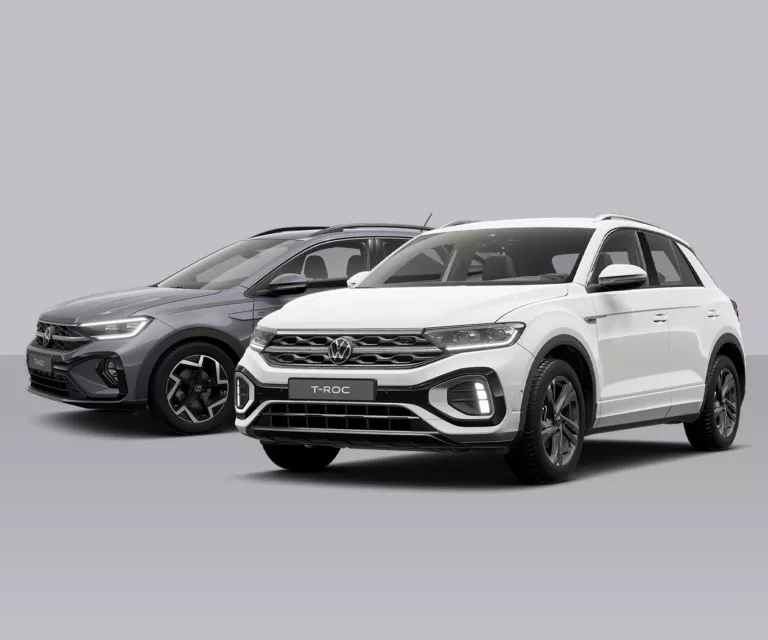 VW Taigo und T-Roc nebeneinander, einer grau, einer weiß, beide von der Seite und leicht von vorne sichtbar.