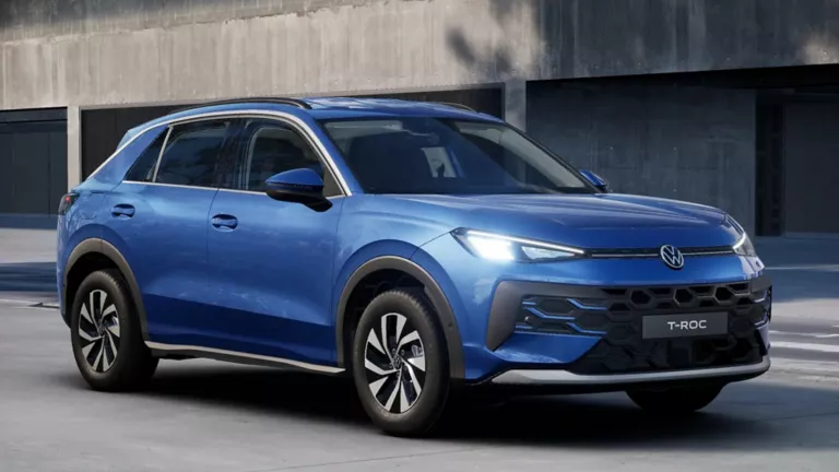 Eine 3/4-Rückansicht eines blauen Volkswagen T-Roc Life, parkend vor einem Gebäude.