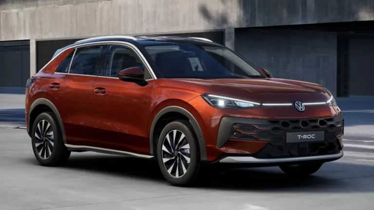 Eine 3/4-Rückansicht eines roten Volkswagen T-Roc Style, parkend vor einem Gebäude.