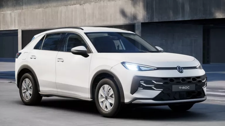 Ein weißer Volkswagen  T-Roc R Trend steht in 3/4-Frontansicht vor einem Gebäude.