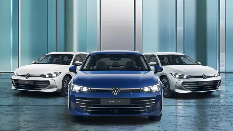 Drei VW Passat nebeneinander, mittleres Fahrzeug blau, die beiden äußeren weiß, frontal aufgenommen vor einer modernen Glasfassade