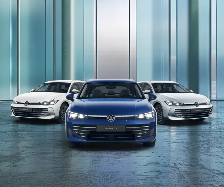 Drei VW Passat nebeneinander, mittleres Fahrzeug blau, die beiden äußeren weiß, frontal aufgenommen vor einer modernen Glasfassade