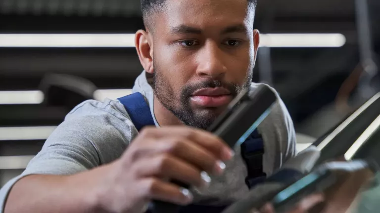 VW-Servicemitarbeiter untersucht eine Windschutzscheibe nach Schäden – Glasreparatur Service  