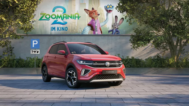VW T-Cross  vor Betonwand mit Werbung für den zweiten Teil des Zoomania Films