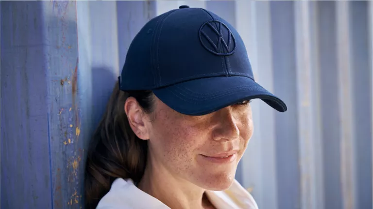 Una mujer sentada dentro de un Volkswagen y un hombre de pie asomado por la ventanilla