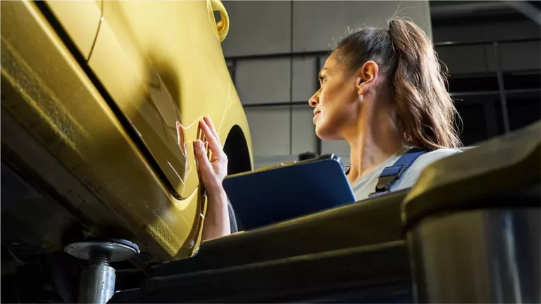 Dos personas delante de un Volkswagen subido a una plataforma