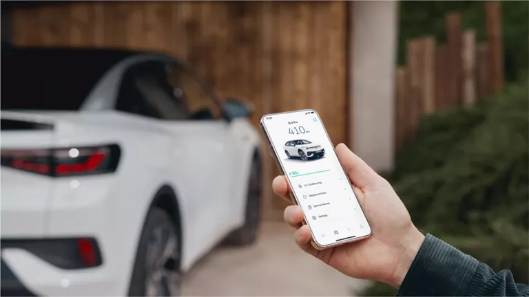 Una mujer de espaldas mirando el móvil y un Volkswagen de fondo