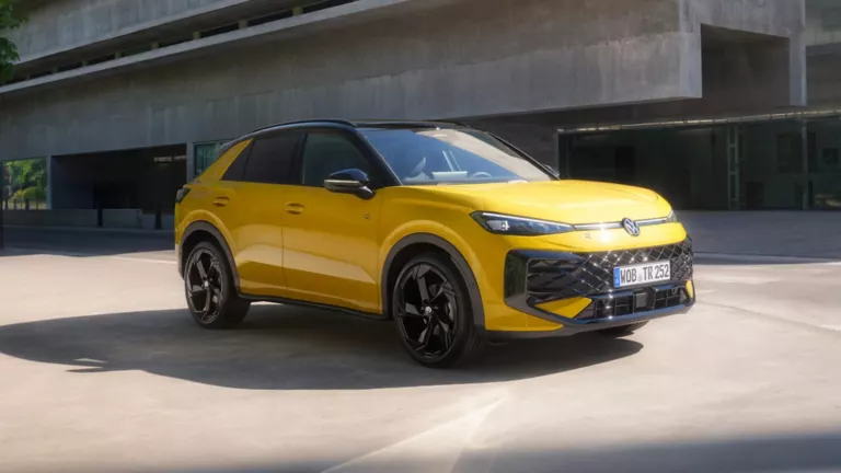 Volkswagen T-Roc amarillo parado junto a un edificio de hormigón