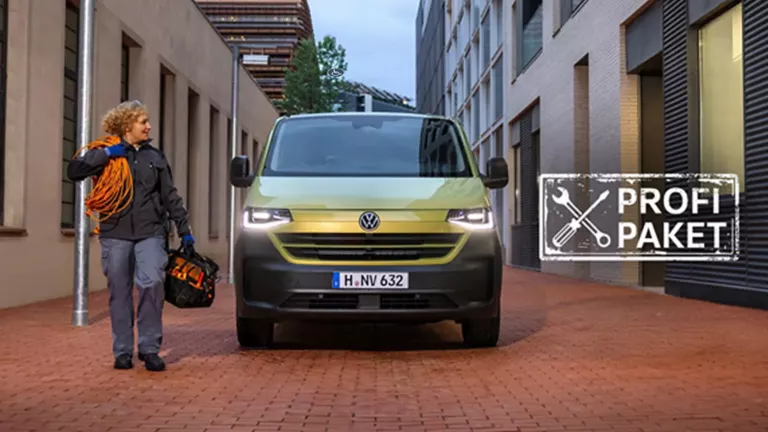 Wir sehen eine Elektronikerin für Energie- und Gebäudetechnik  in Arbeitskleidung, die gerade an Ihrem Transporter vorbei geht.