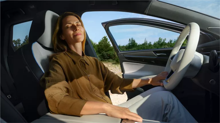 Una agente de servicio revisando el motor de un Volkswagen