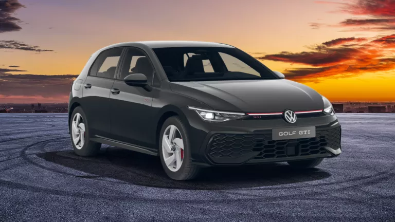 VW Golf GTI parkt auf Asphalt, im Hintergrund ein Sonnenuntergang