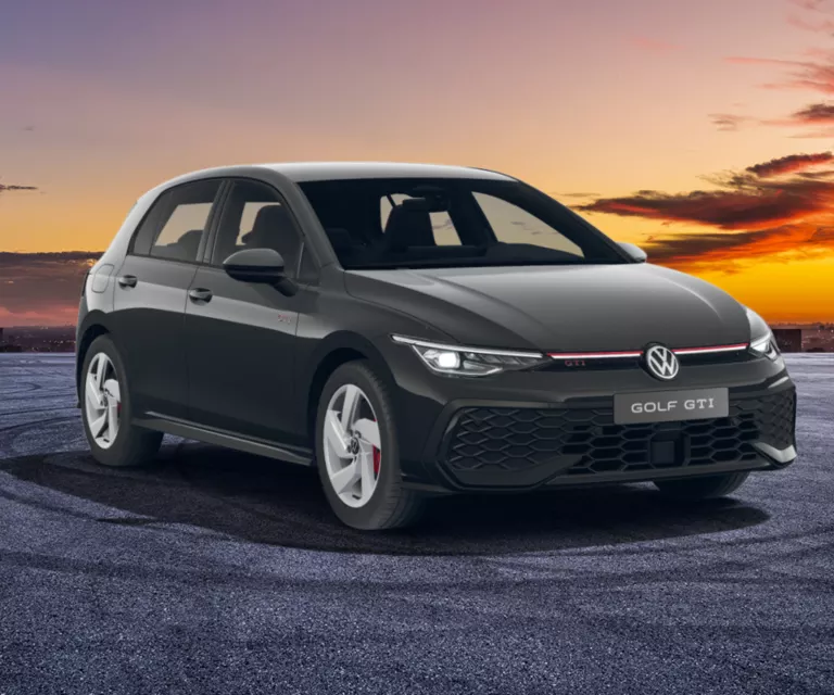 VW Golf GTI parkt auf Asphalt, im Hintergrund ein Sonnenuntergang