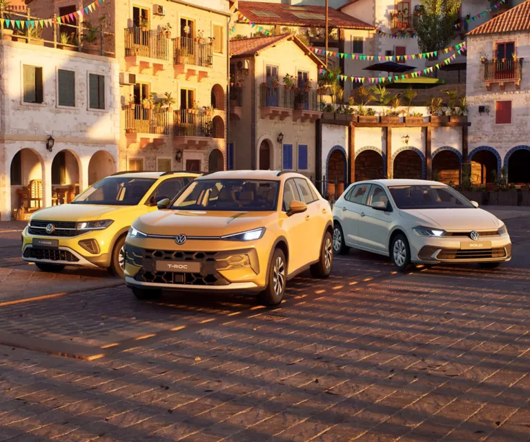 VW Golf, VW T-Roc und VW Tiguan stehen nebeneinander auf einer Straße. 