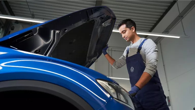Una mujer junto a un empleado del servicio técnico de Volkswagen