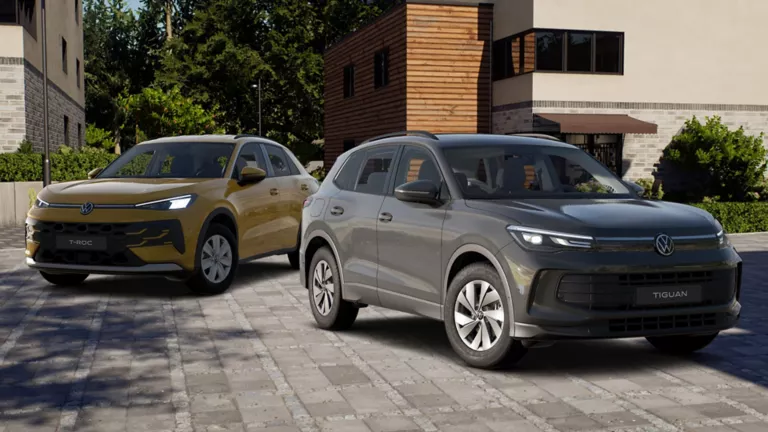 VW T-Roc und VW Tiguan stehen vor eienr Hausfront.