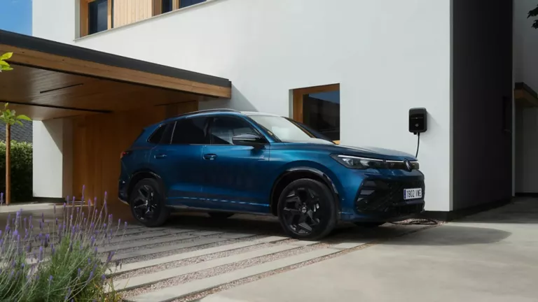 Un Volkswagen Tiguan azul cargando en una casa