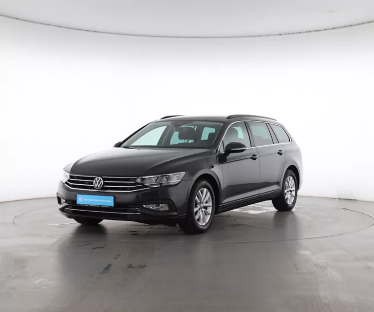 Vier Volkswagen-Elektroautos stehen auf einem ländlichen Weg vor einer bewaldeten Hügellandschaft