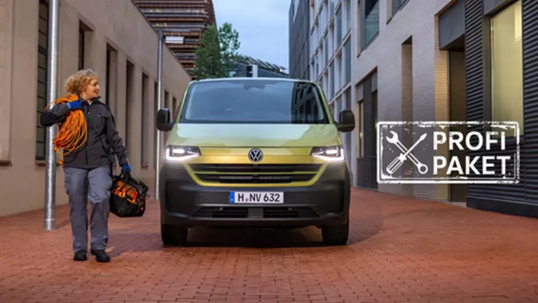 Wir sehen eine Elektronikerin für Energie- und Gebäudetechnik  in Arbeitskleidung, die gerade an Ihrem Transporter vorbei geht.