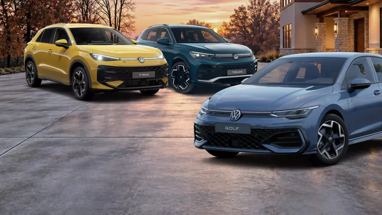 VW T-Roc, VW Tiguan und ein VW Golf parken nebeneinander in großen Hauseinfahrt.